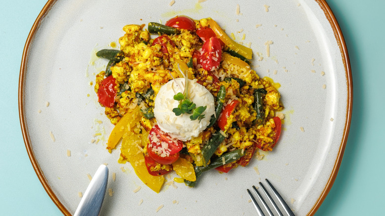 Scrambled tofu with tomatoes, green beans, and cheese.