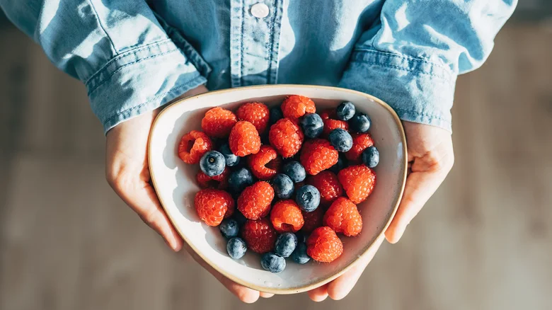 woman holding a plate of berries in her hands