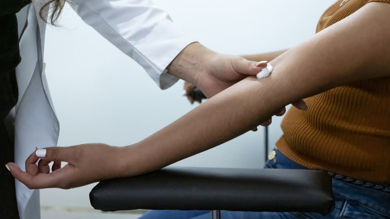 Nurse putting a cotton wool pad where she drew blood