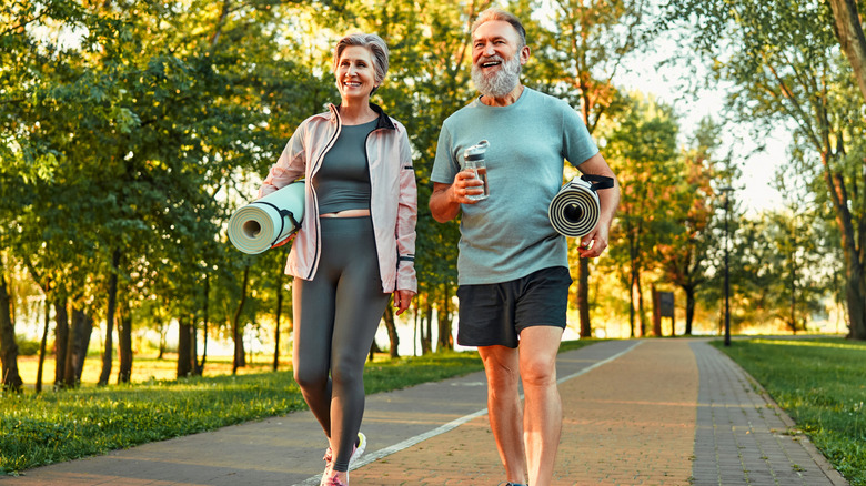 Smiling middle-aged couple going to workout outdoors