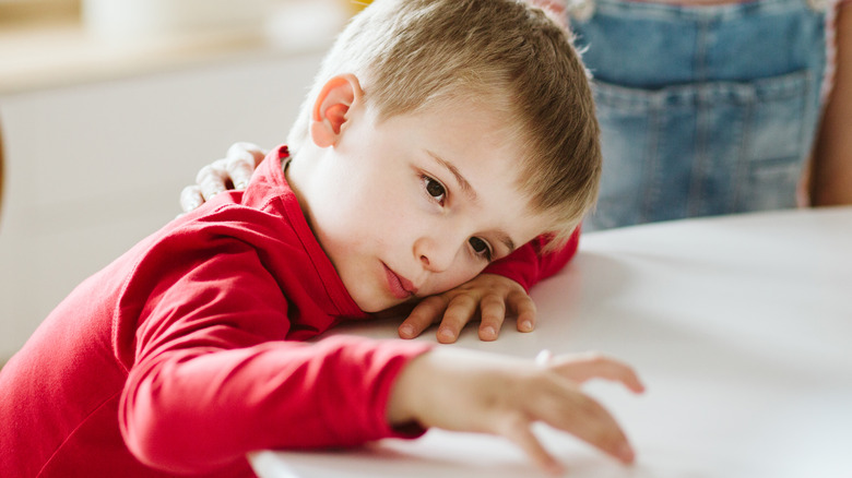 young boy distracted from mom