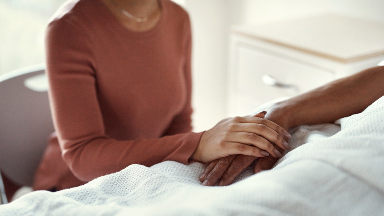 Woman holding loved one's hand