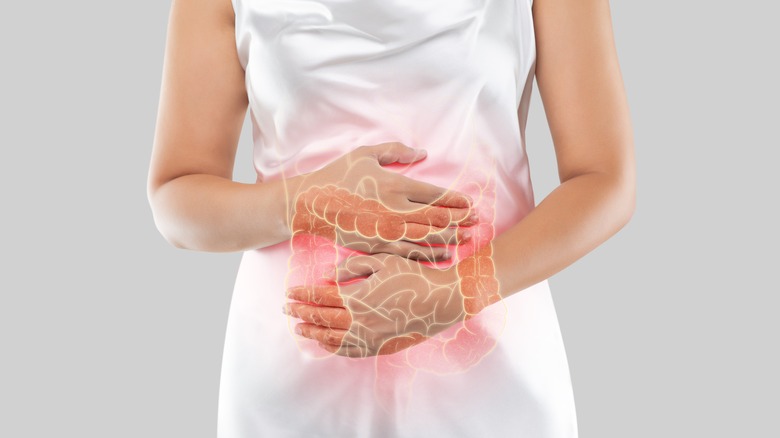woman holding stomach with colon