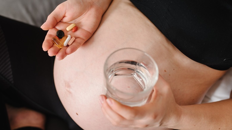 Pregnant woman with handful of pills
