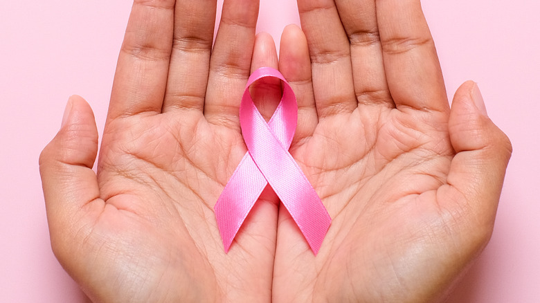 hands holding pink ribbon