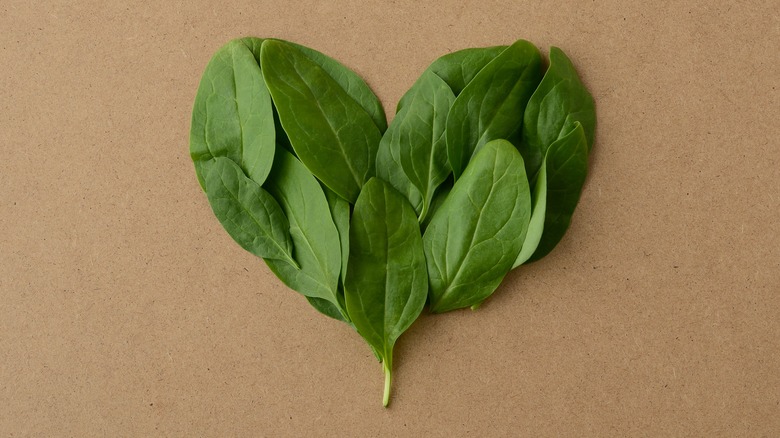 spinach heart concept on brown surface