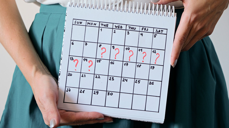 woman holding calendar with question marks