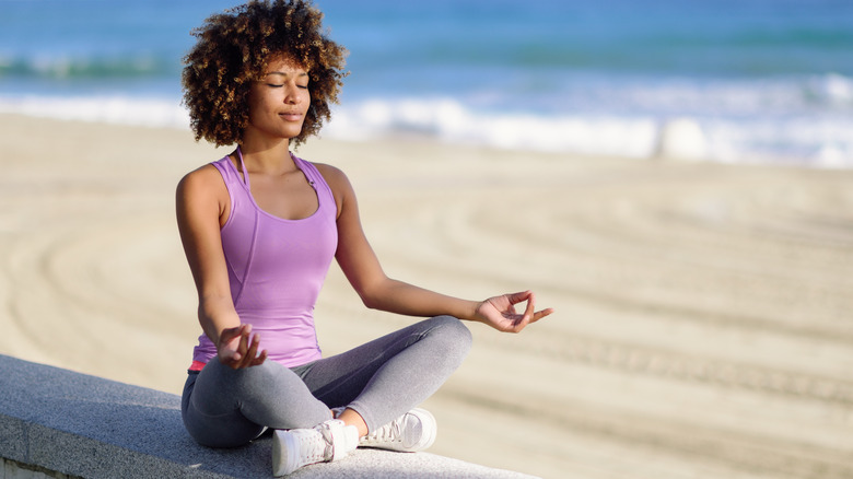 woman meditating on beach