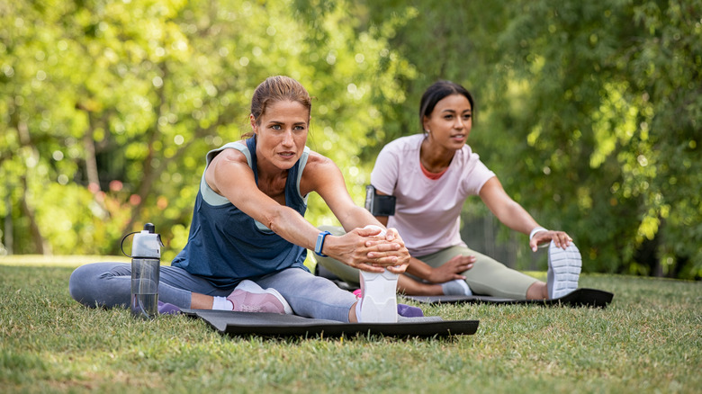 Two women stretching outside