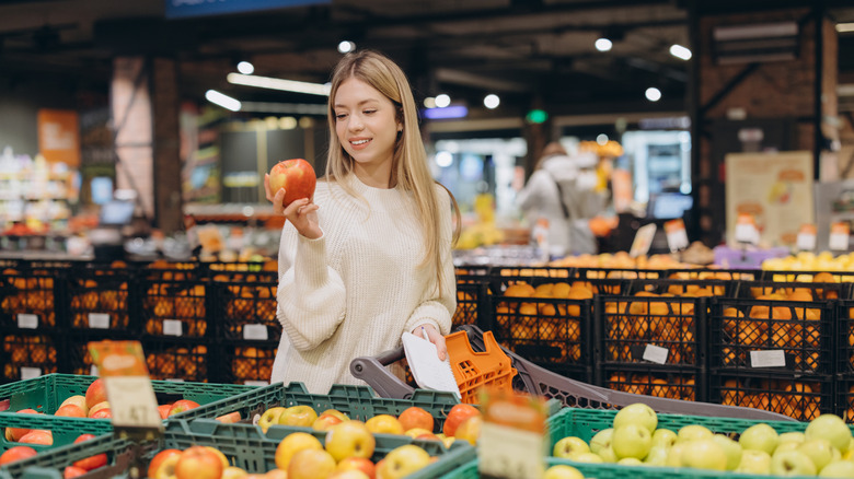 young woman shopping for apples