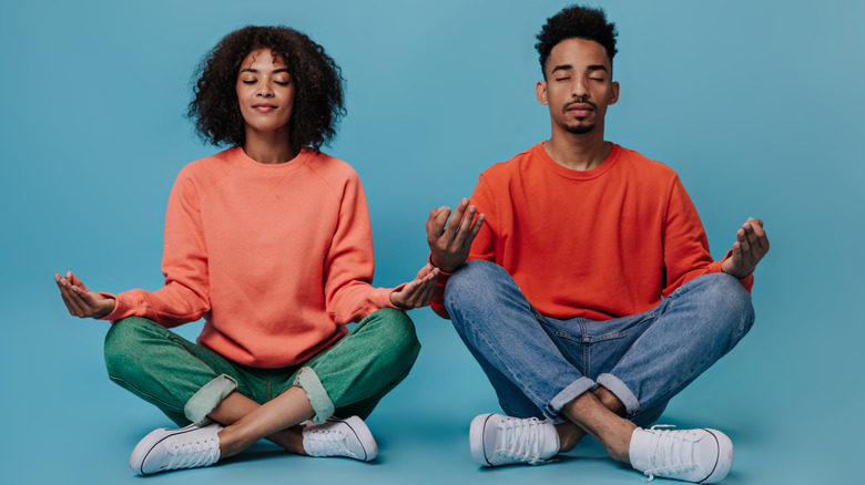 couple sitting on floor meditating