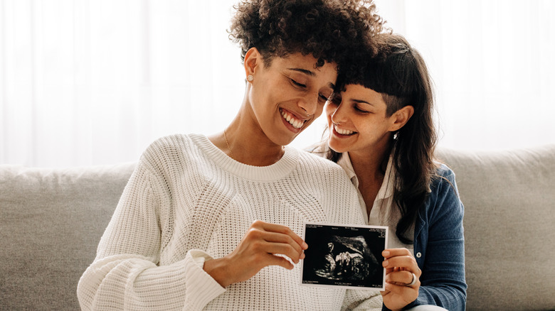 Same sex couple holding sonogram