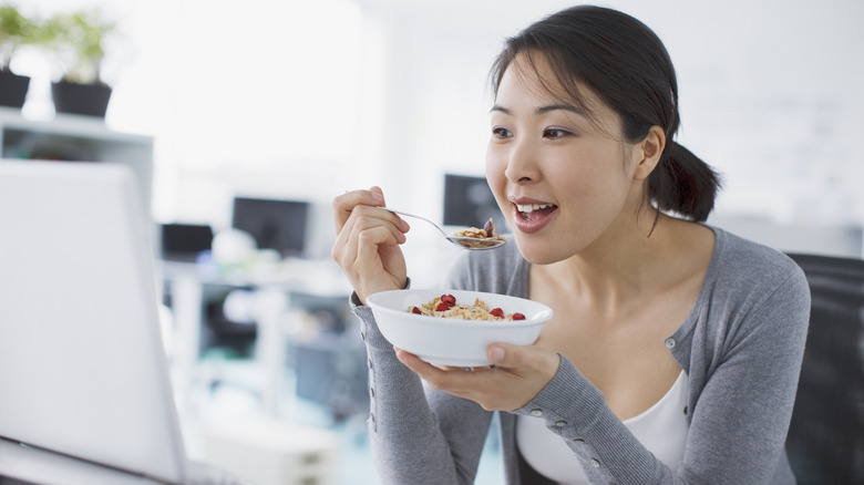 woman eating a bowl of oatmeal for breakfast