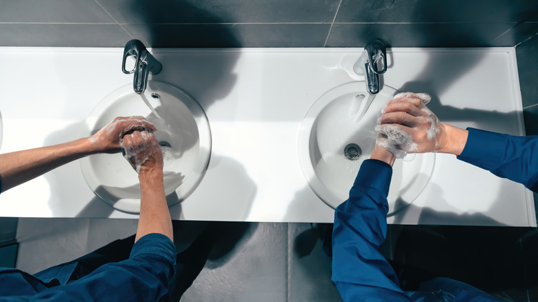 Two people washing their hands in the restroom