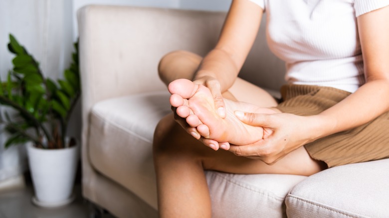 woman rubbing her foot