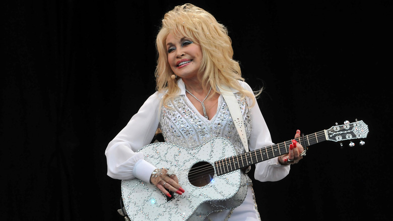 Dolly Parton playing the guitar