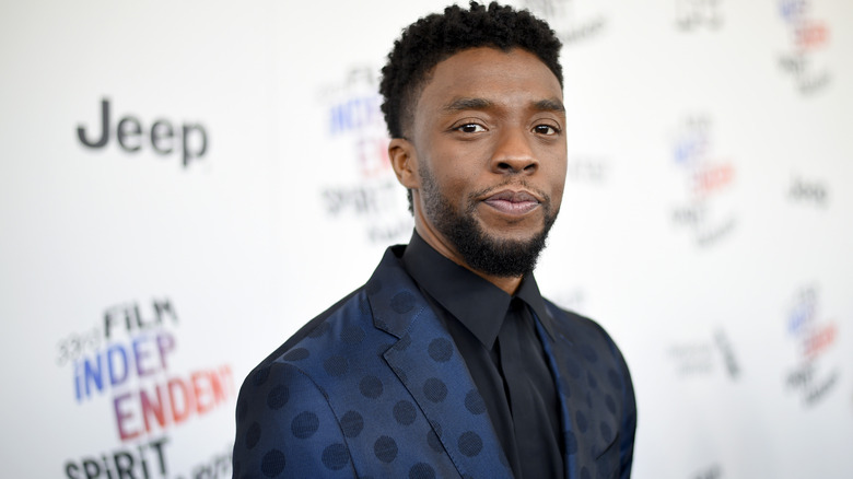 Chadwick Boseman posing in a blue suit