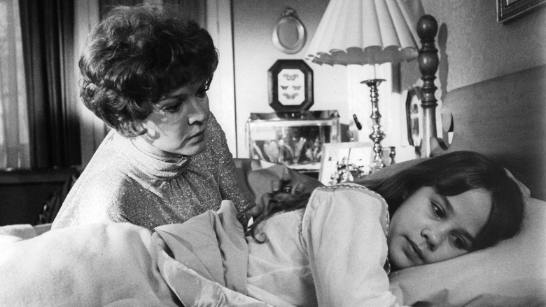 On the set of The Exorcist, Linda Blair lying in bed with Ellen Burstyn leaning over her.