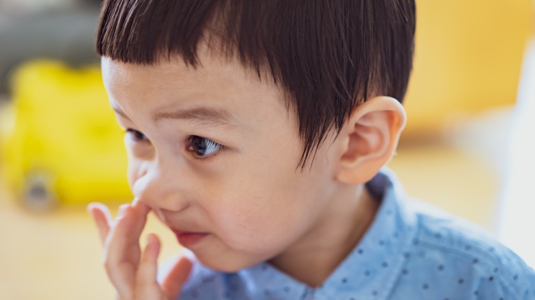 little boy picking his nose