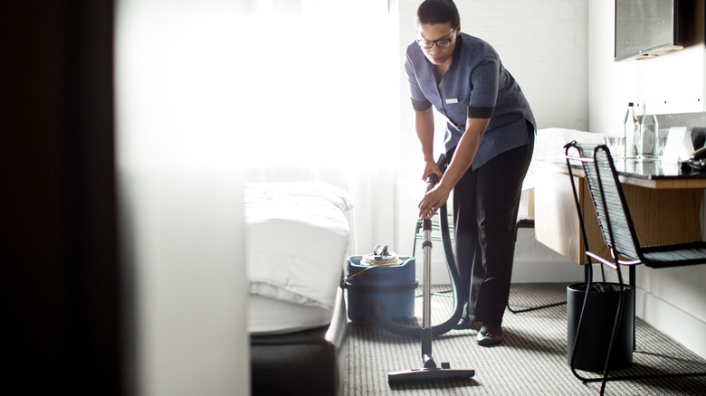 Housekeeper vacuuming the hotel floor