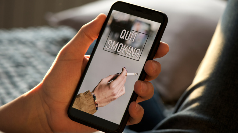 picture of a man holding a cell phone with the words quit smoking