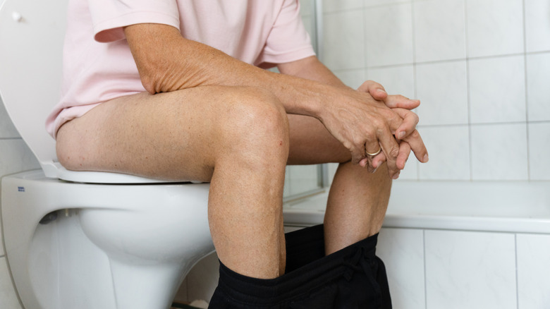 Constipated man sitting on toilet