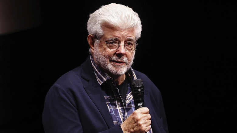 George Lucas speaking on stage during an event