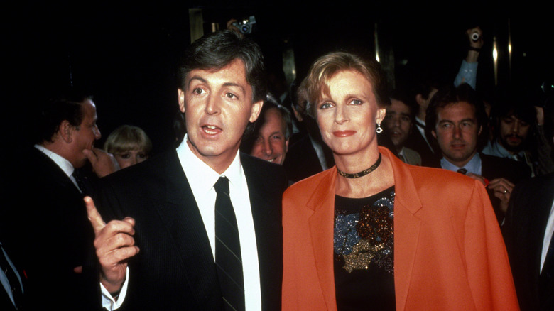 Paul McCartney gesturing while Linda McCartney smiles