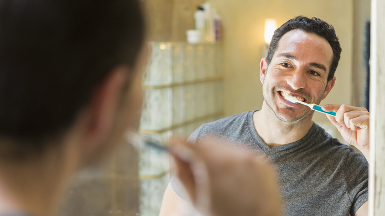 A man brushing his teeth and taking care of oral hygiene