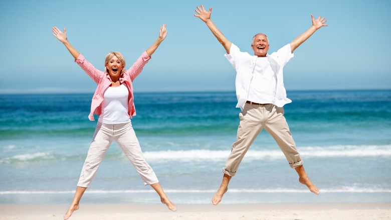 happy couple jumping on the beach