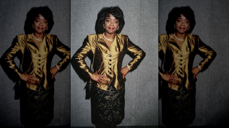 Oprah Winfrey posing in a golden jacket