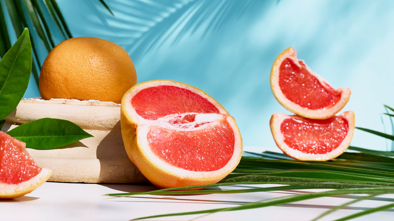 A sliced grapefruit on a tropical background