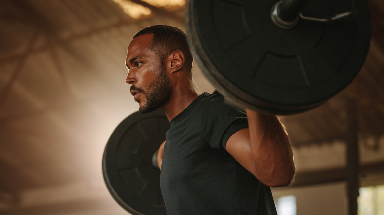 A man lifts a heavy barbell