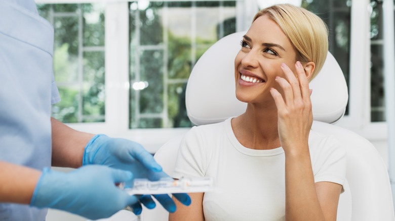 Smiling woman speaking to plastic surgeon