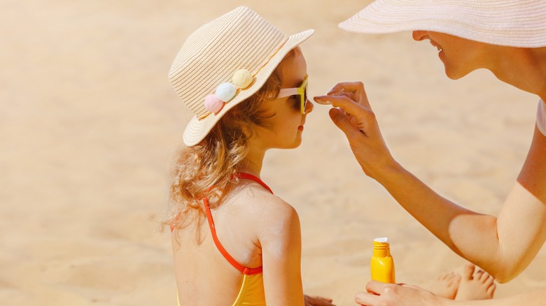 mom puts sunscreen on daughter 