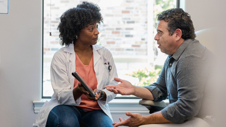 Man speaking to doctor holding test results