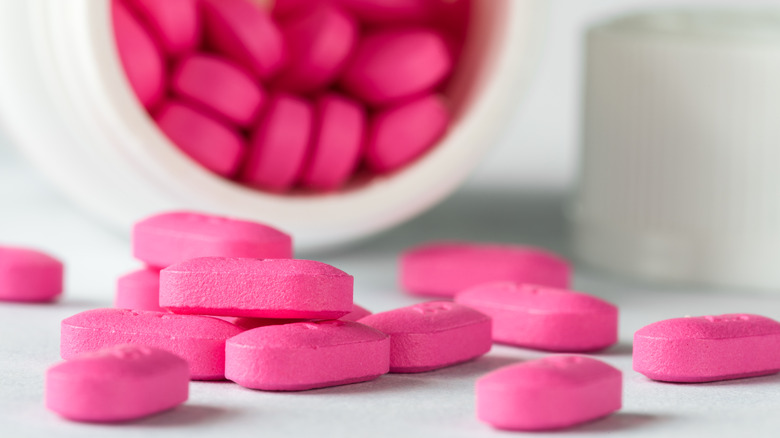 Pink Benadryl pills poured from bottle