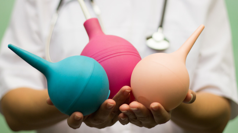 medical professional holding three enemas