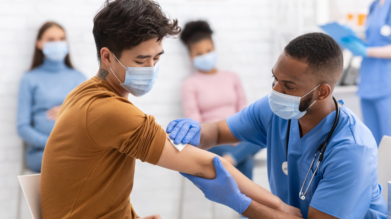 nurse giving man covid vaccine