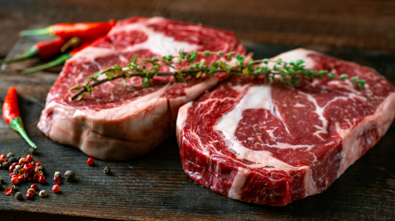 raw, garnished rib-eye steak