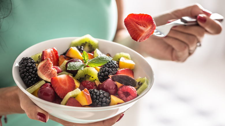 A woman's hands holding a bowl of berries