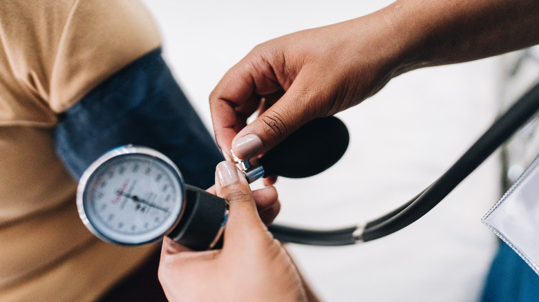 nurse hand putting blood pressure monitor on patient