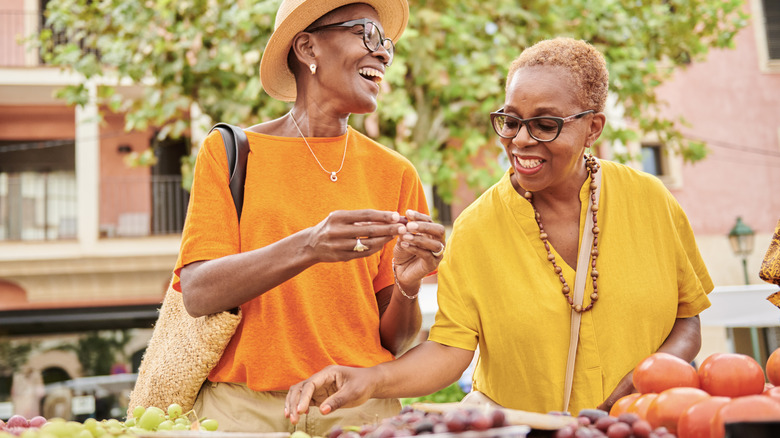 Two women shopping for vegetables at a farmer's market in Spain