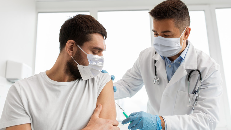 Patient receiving vaccine from doctor