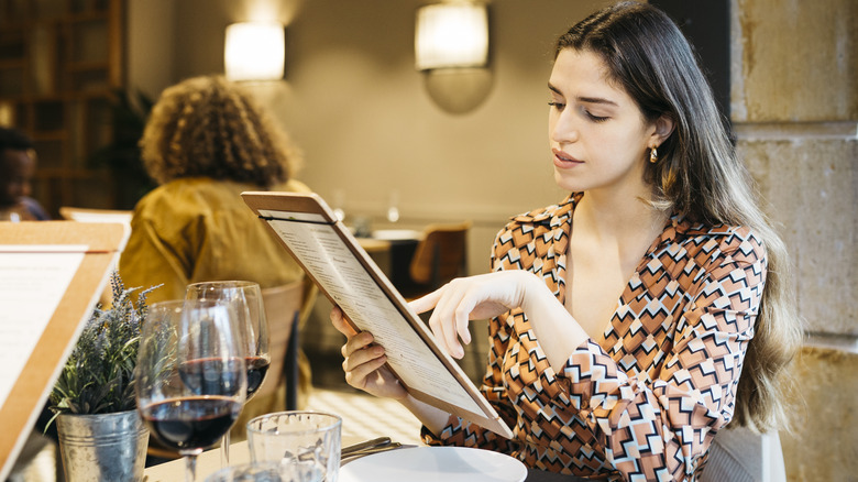 A woman looking at a menu in a restaurant