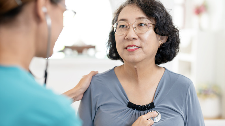A woman getting her heart checked by a stethoscope