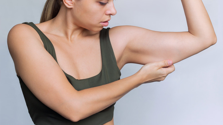 Woman pinching her arm