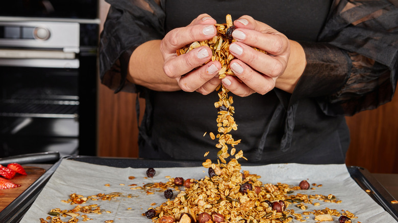 woman making homemade granola in kitchen at home