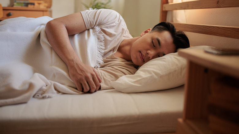 young man sleeping in bed at home