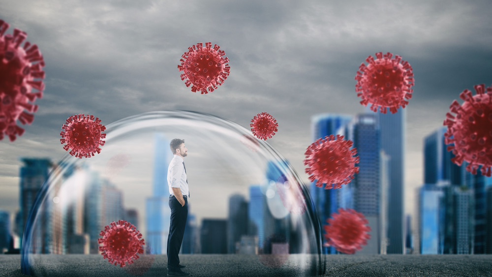 Businessman inside a shield dome that protects him from virus.